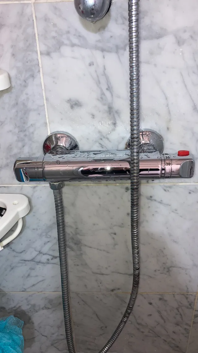 Mitigeur thermostatique de douche posé sur faïence marbre